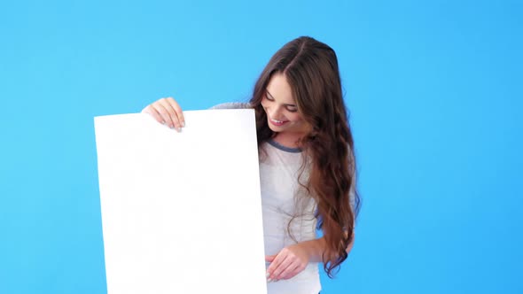 Beautiful woman holding blank placard and showing thumbs up alt