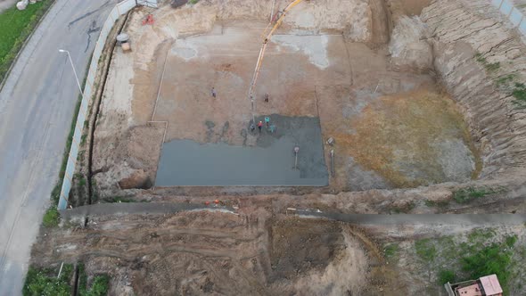 Aerial view construction workers pouring concrete at construction site basis.