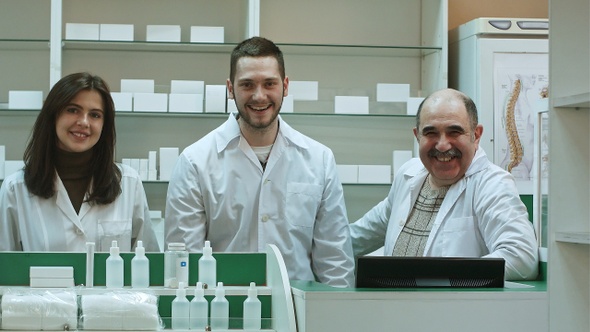 Three Competent Pharmacists Laughing in A Pharmacy Looking