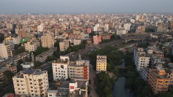 Aerial View Over Dense Metropolitan Cityscape Condominiums With Highway Running Past. Pedestal Down alt