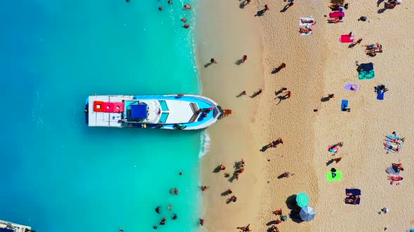 View of Navagio beach, Zakynthos Island, Greece. People relaxing on the beach during their vacation. alt
