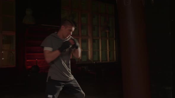 Cool Man Fighter in Boxing Bandages Trains in the Gym alt