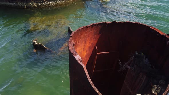 Close-up panning shot of the ruined smoke stack from the sunken World War II battleship USS Arizona alt