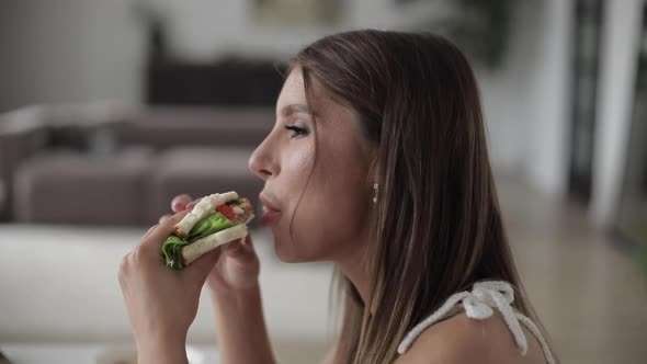 Beautiful Lady Enjoying Sandwich During Lunch in Room