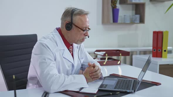Physician therapist videoconferencing on computer. Doctor having video conference on laptop alt