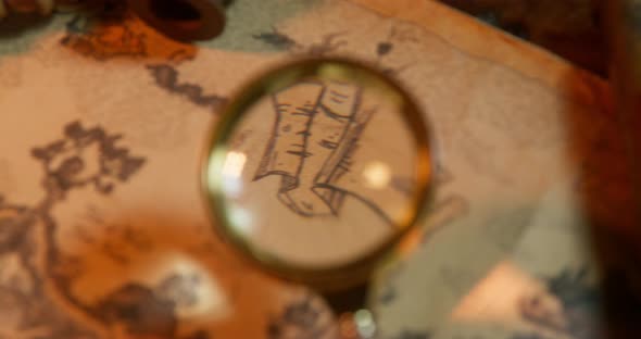 Person Carefully Examines an Ancient Map with a Magnifying Glass Trying to Find the Place Where the