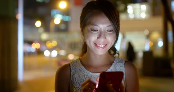 Woman use of mobile phone at outdoor in the evening alt