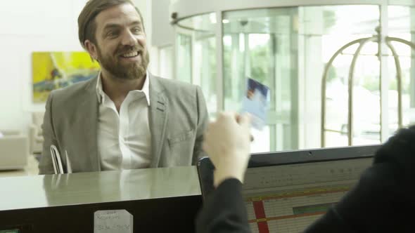Businessman checking into hotel alt