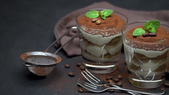 Two Portions Classic Tiramisu Dessert in a Glass on Dark Concrete Background alt