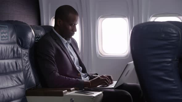 Businessman using laptop computer on airplane