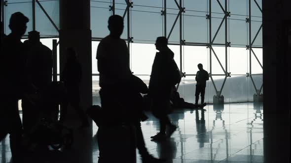 Silhouette of Passing People in Airport Terminal alt