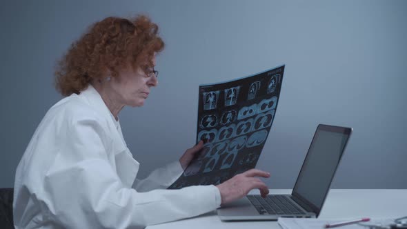 Female Radiologist Describes Patients Tomography Results By Typing on Laptop While Sitting in alt