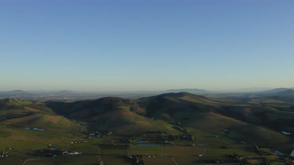 Aerial of hills, vineyard farmlands landscape and ponds, Stellenbosch, pan down alt