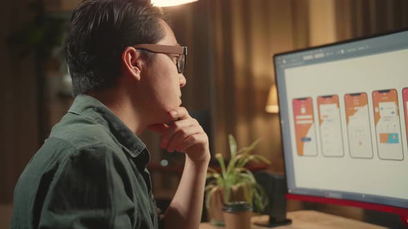 Asian Male Mobile Application Developer Thinking While Works With Graphics On His Personal Computer alt