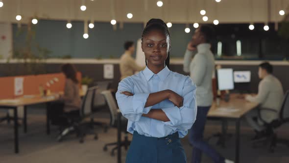 Young African American Handsome Businesswoman Looking at the Camera Standing in Modern Office with alt