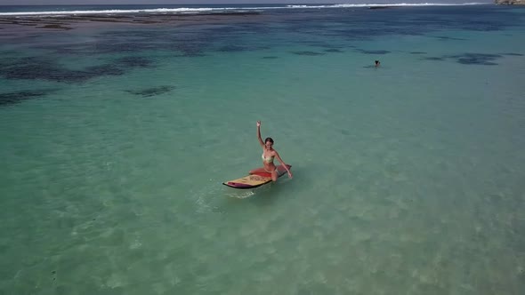 Woman Relaxing in the Sea on a Surfboard