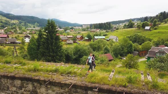 A couple walks along the old viaduct in the mountains Ukrainian Carpathians