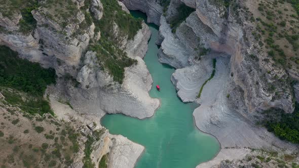 Top view of a mountain river in the canyon and  boat sailing along a turquoise river among the rocks