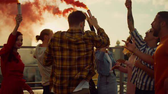 Partying Friends Having Fun with Smoke Bombs at Rooftop alt