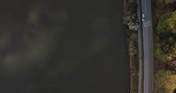 Scenic lake footpath alongside road with moving cars alt