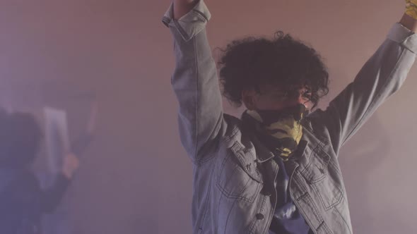Diverse group of people wearing face masks holding protest signs alt