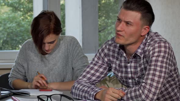 Male Student Taking Off His Glasses, Looking Tired While Studying alt