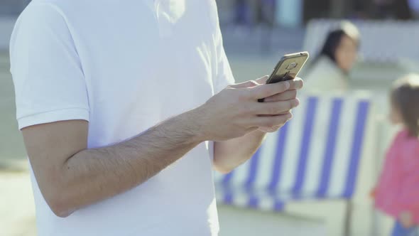 Cropped Shot of Young Man Texting on Smartphone alt
