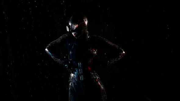 Woman in Black Latex Suit and Mask is Dancing in Rain in Darkness Medium Shot alt