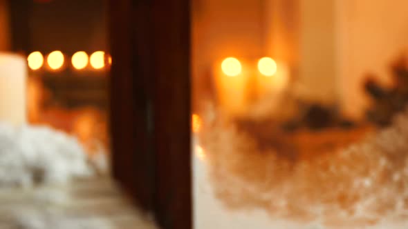 Snow with candles and pine cone on a wooden plank alt