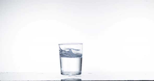 Glass Falling and Water splashing against White Background, Slow Motion 4K
