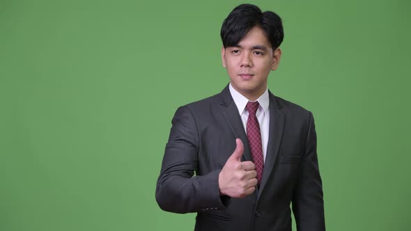 Young Handsome Asian Businessman Giving Thumbs Up alt