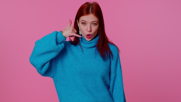 Cheerful Girl in Blue Sweater Looking at Camera Doing Phone Gesture Like Says Hey you Call Me Back alt