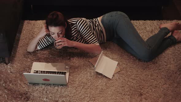 Young adult woman on floor working on laptop