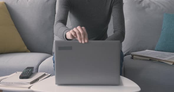 Woman working with a laptop and smiling at camera