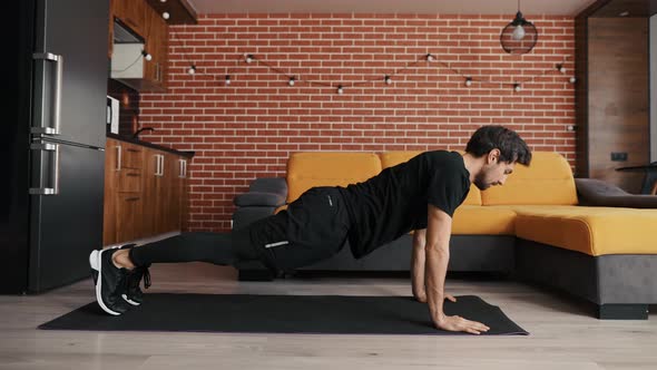 A European Man Works Out Doing Pushups Lying on a Mat alt