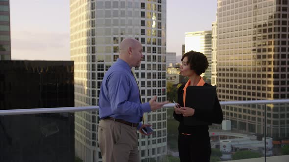 Businesspeople meet on rooftop and shake hands