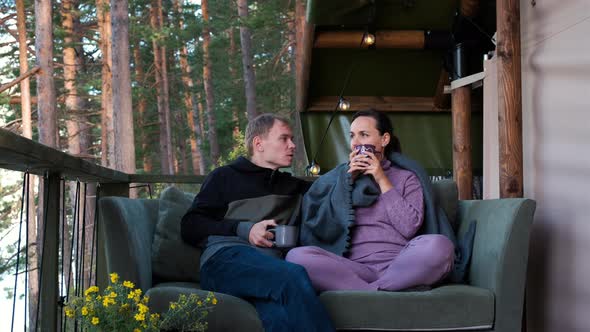 Man and Woman Drinking Tea While Luxury Camping alt