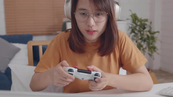 Young asian women play video game relaxing in free time sits at home