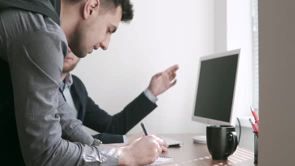 Two Concerned Workers in a Meeting in an Office Looking at Each Other with Serious Expressions alt