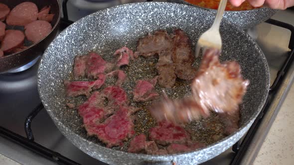 Sausage and beef cutlet cooked in a pan on the stove, breakfast preparation, breakfast preparation a alt