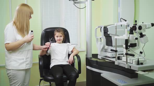 an Ophthalmologist Diagnoses a Little Girl's Vision on a Sign Projector alt