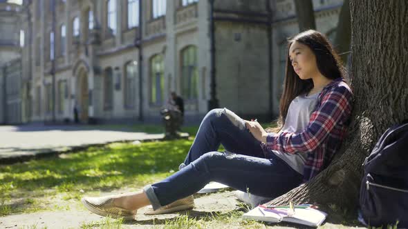 Multinational Young Woman Sitting Calmly Under Tree With Closed Eyes, Relaxation alt