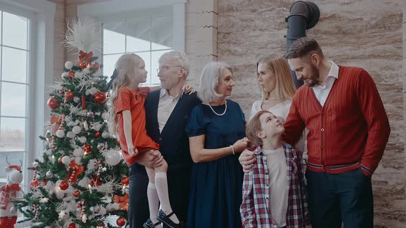 Family with Kids and Grandparents Dressed Up for Christmas Eve Look at Camera