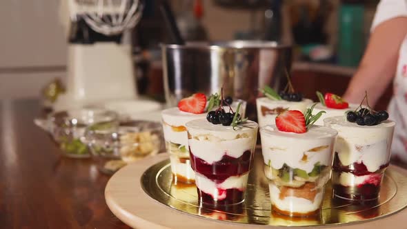 Glasses with Sweet Fruit Mousse with Cream Are Standing in a Round Plate alt