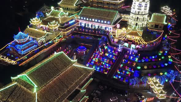 Drone shot with slowly rise up to reveal Kek Lok Si temple in night alt
