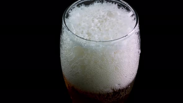 Glass Of Beer Foamy Close Up.On A Black Background.Pouring Beer