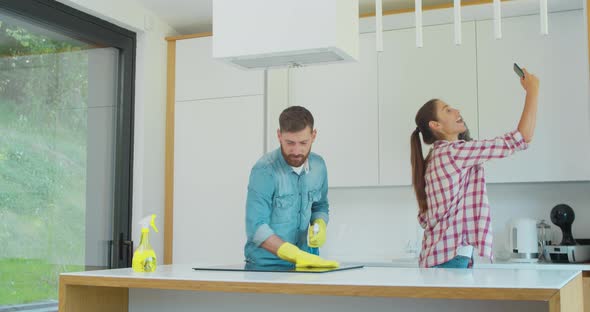 Man and Woman As a Professional Cleaners in Uniiform Having Fun During the Work on the Kitchen.