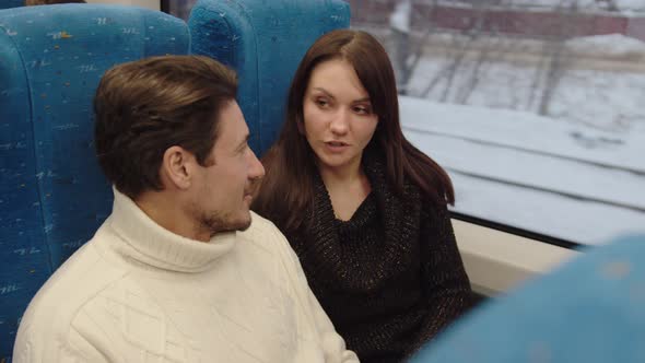 A Middleaged Couple are Talking and Smiling in a Train Carriage