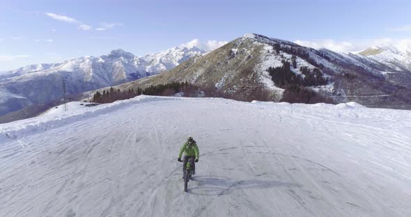 Backward Aerial Over Biker Man Cycling on Snowy Path During Winter with Mtb Ebike alt
