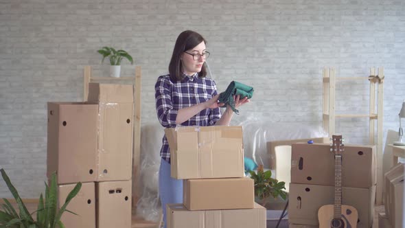 Portrait Young Woman in Plaid Shirt Unpacking Boxes Moving To New Home alt